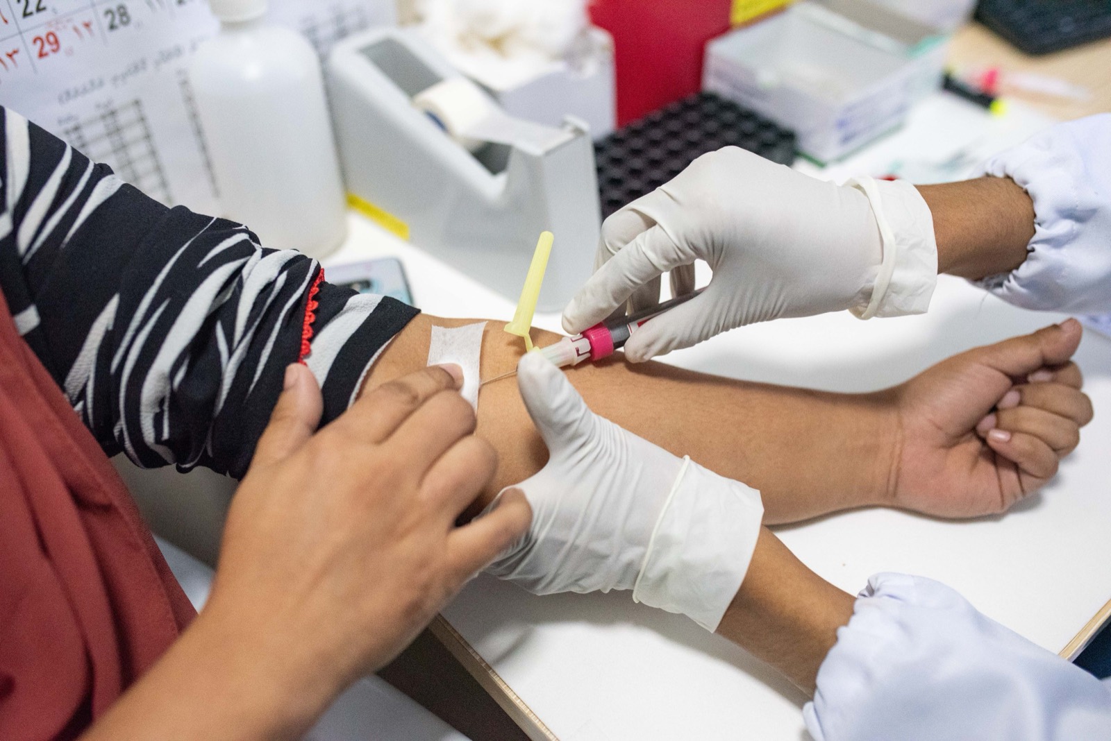 Phlebotomy student drawing blood in training